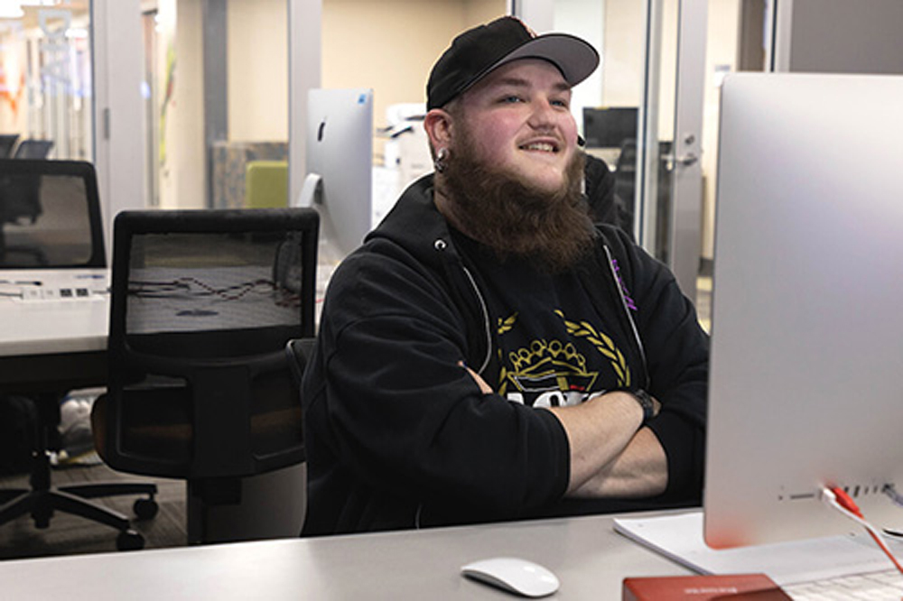 man smiling behind computer